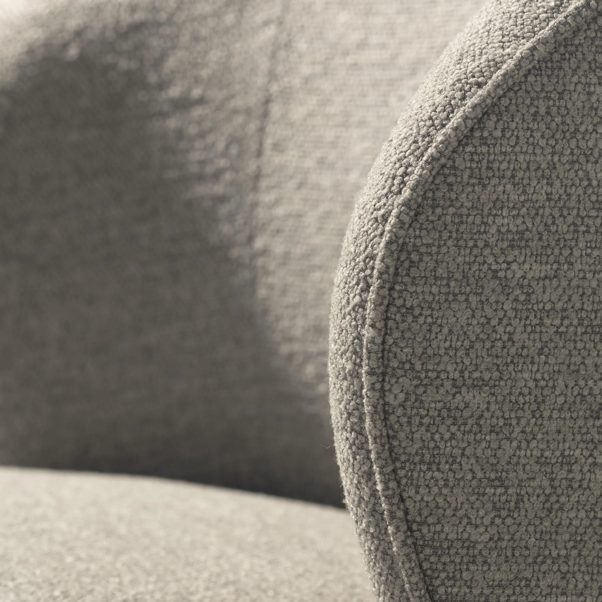 Sillón Edna Gris tapizado con formas envolventes y diseño giratorio para salón