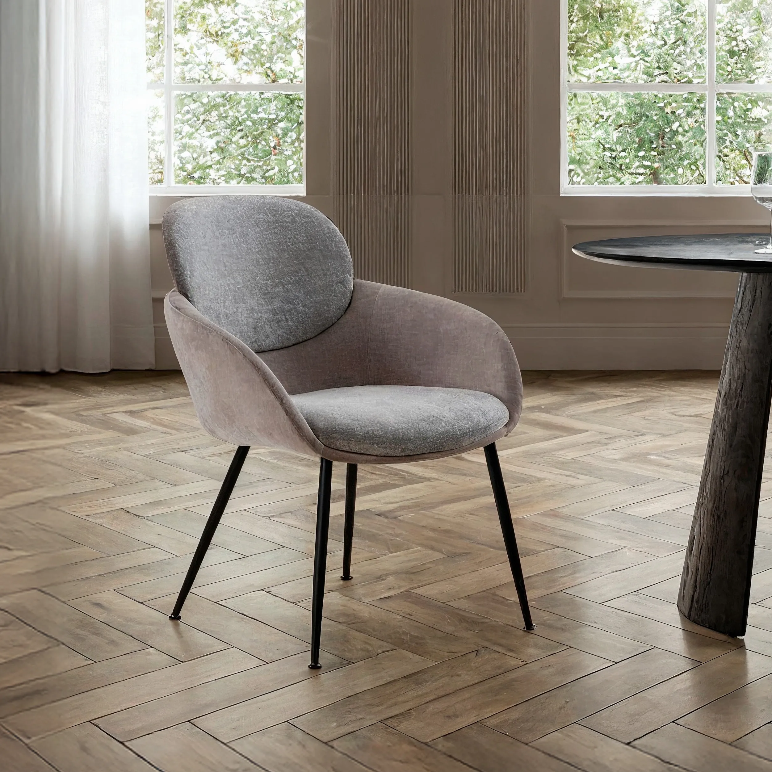 Sillón Nure Gris tapizado con respaldo redondeado, reposabrazos y patas metálicas negras