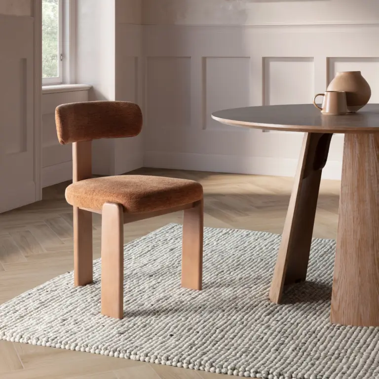 Silla Nadia con asiento y respaldo tapizados en color teja y estructura en acabado roble lavado.